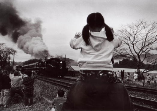 蒸気機関車を見送る少女の画像